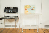 Transparent Lucite leg detail with a spherical rolling caster on the vintage cart.