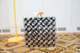 Vintage Lucite cube top with black checker art, two wooden animal toys.