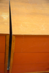 Adjacent George Nelson dressers, showing wood tops, burnt orange fronts, and surface wear.
