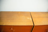 Scratches and worn varnish on the wooden tops of Herman Miller dressers.