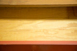 Vintage George Nelson dresser drawer interior, light wood with burnt orange front edge.