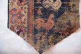 Antique West Persian rug fragment detail showcasing rooster motifs and geometric border.