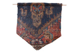 Antique Kurdish rug fragment wall flag with geometric designs in deep navy, rust red, and tan.