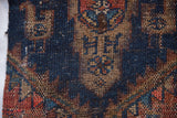 Rustic geometric motifs and timeworn texture on a hand-knotted Kurdish rug fragment.