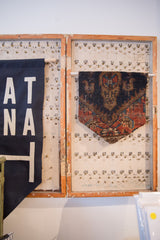 Limited edition RUGLING wall hanging displayed as unique art inside a rustic wooden cabinet.
