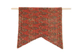 A hand-crafted flag wall hanging made from an antique red Mir Serbend Persian rug fragment.
