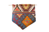 Antique Turkish Kilim rug fragment wall hanging displaying geometric patterns in vibrant teal, rust, and green.