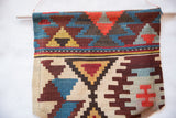 Geometric stepped motifs of an antique Turkish kilim fragment in rust, blue, and beige.