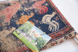 A postcard pinned to the antique Persian rug cork board, demonstrating its unique use.