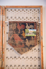 Antique Persian rug fragment cork board styled with a vintage postcard pinned to its surface.