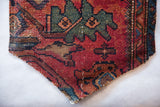 Hand-knotted vintage Lilihan rug fragment corner with red, teal, and brown patterns.