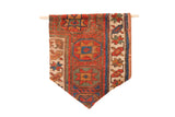 RUGLING 02 wall hanging with antique Kurdish rug fragment, geometric red, blue, and green patterns.