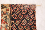 RUGLING 03: Antique Northwest Persian rug fragment, geometric border, dark field, wooden dowel.