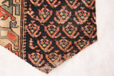 Stylized motifs in muted coral and beige on deep indigo ground of antique Northwest Persian rug fragment.