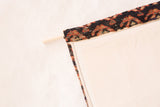Top edge of RUGLING showing hand-knotted antique Northwest Persian rug fragment and dowel.