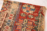 Geometric designs in brick red, beige, and sky blue on the antique Caucasian Soumac Rugling.
