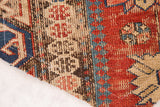 Textured close-up of antique Caucasian Soumac fragment, red, blue, beige geometric weave.