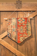 Antique Caucasian Soumac rug fragment wall hanging with red, blue, and neutral geometric motifs.