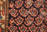 Worn dark blue, brick red, and green geometric motifs on an antique Northwest Persian rug fragment.