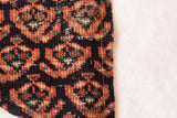 Antique Northwest Persian fragment: dense geometric-floral weave, terracotta, sage green, dark ground, and stitched edge.