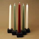 Bases and lower sections of square natural and green beeswax taper candles.
