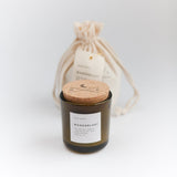 Dark glass Wanderlust Soy Candle with white label and cork compass lid.