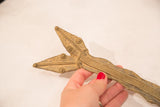 Hand holding vintage bronze Lobi snake, showing intricate head details and geometric body texture.