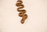 Close view of the handmade iron snake's head resting on its rusty, twisted body.