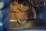 Rustic texture and rich patina of the coiled iron snake sculpture.