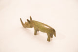 Side view of a vintage bronze rhinoceros showing its handmade form and green patina.