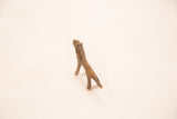 Handmade vintage bronze lion sculpture, showing its textured, slender body.