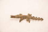 Side profile of a handmade bronze crocodile showing its dark patina and etched details.