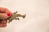 Side view of a vintage crocodile gold weight showing its textured body and aged patina.