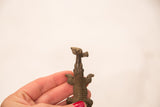 Handheld collectible bronze crocodile sculpture with textured body and fish.