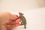 A view of the handmade texture and oxidized patina on the back of a vintage porcupine bronze weight.