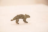 The walking stance of a vintage handmade bronze porcupine with textured quills.