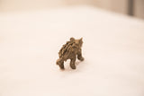 Rear angle of a vintage porcupine sculpture showing its dark patina and textured quills.