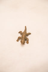 Top-down view of a vintage Ashanti lizard gold weight with textured bronze finish.