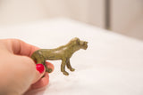Hand-held view of the vintage bronze lioness, revealing its aged green patina.