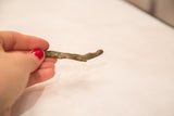 Vintage bronze crocodile gold weight held in hand to illustrate its small size.