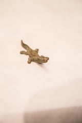 Angled view of the tiny crocodile bronze gold weight showing handmade details.
