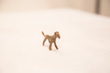 The slender profile and aged bronze texture of a vintage cheetah gold weight figurine.