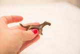 Tiny vintage cheetah bronze gold weight held in hand for size reference.