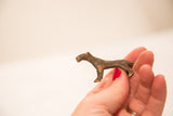 The small scale and textured bronze patina of a vintage cheetah gold weight.