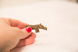 Hand holding a collectible vintage handmade bronze hippo gold weight, featuring unique patina.