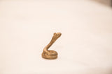 Vintage coiled bronze snake sculpture, showing its distinct handmade texture and patina.