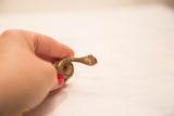 Small vintage bronze snake sculpture held in hand to show its collectible scale.