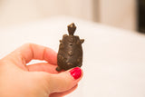 Raised spiral patterns and dark patina on the shell of a vintage bronze turtle weight.