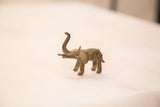 Collectible African bronze elephant sculpture with trunk up and aged patina.