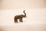 Vintage bronze elephant sculpture with a dark patina, shown in profile with a raised trunk.
